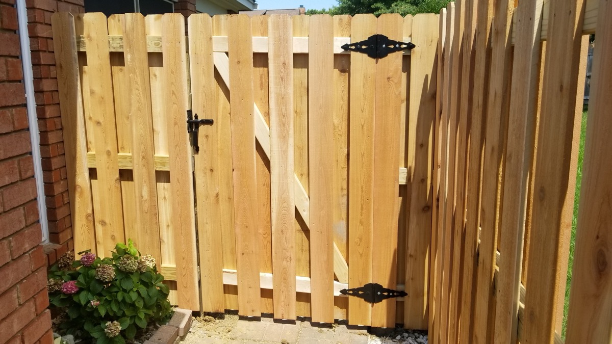 Board-on-board cedar gate close-up with decorative hinges