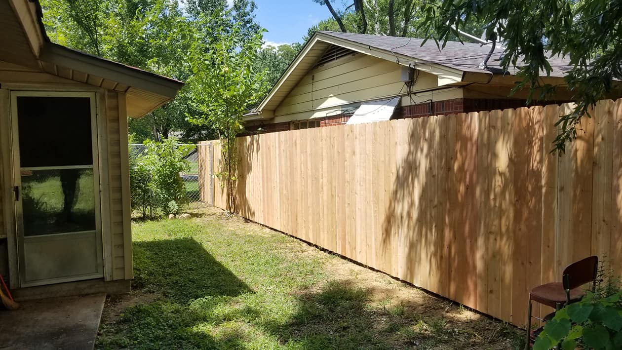 Tall wood privacy fence running along side of house