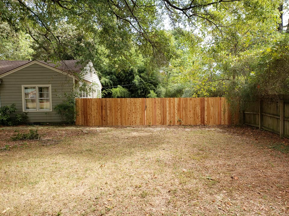 New cedar privacy fence installation in backyard with shed