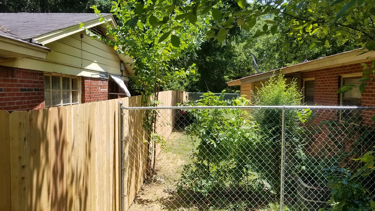 New wood privacy fence installed alongside existing chain link fence